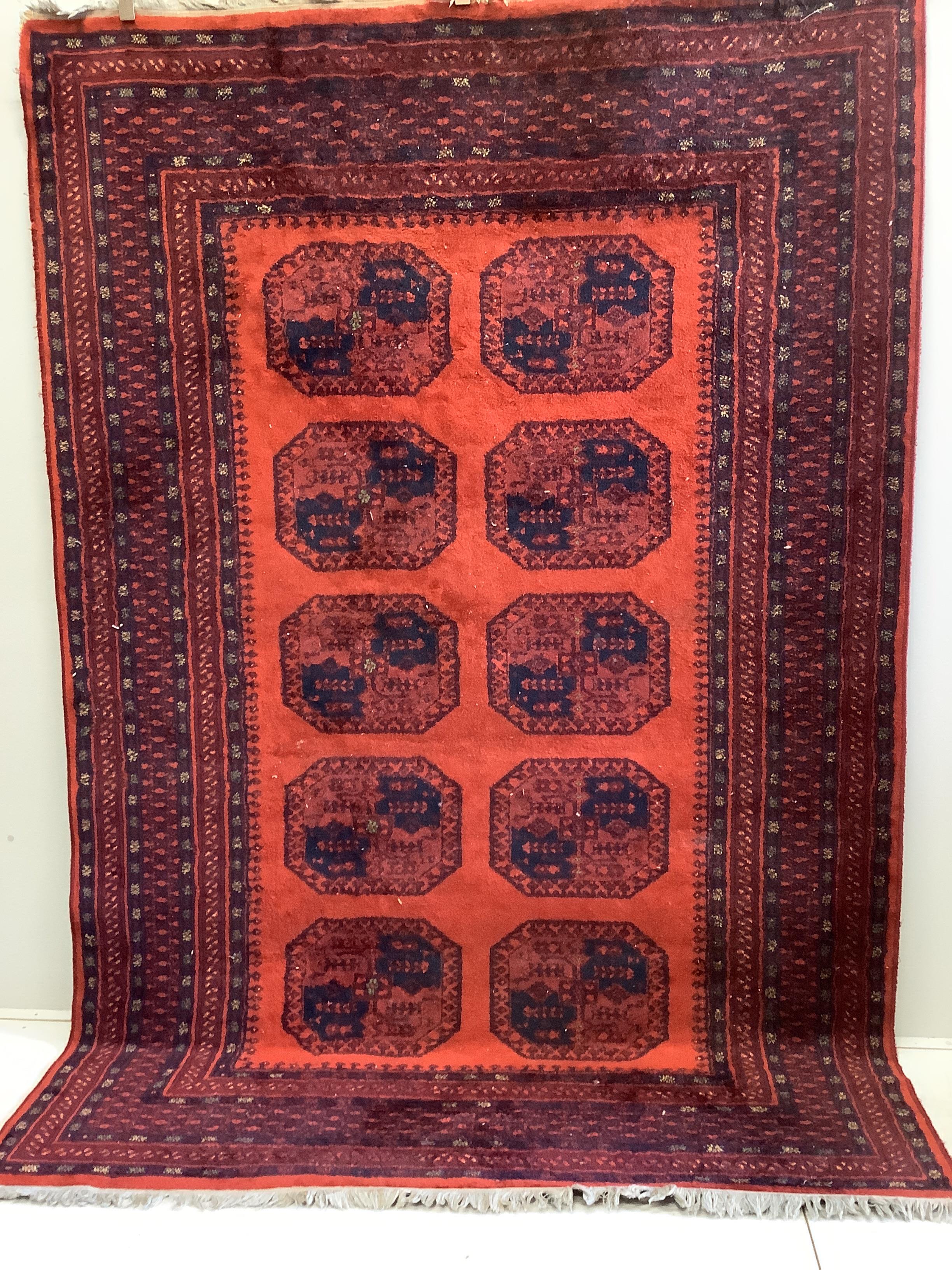 An Afghan style red ground carpet, 280 x 191cm